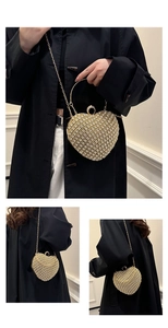Detail of heart-shaped gold clutch with sparkling rhinestones, ring handle and chain strap