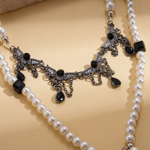 Gothic layered necklace detail with bat wing pendant and black drop gemstone charms