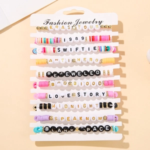 Close-up of multicolored Eras Tour friendship bracelets with polymer clay and letter beads