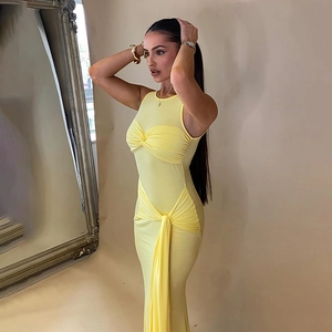 Détail d'une robe moulante jaune sans manches avec un nœud frontal et une taille froncée