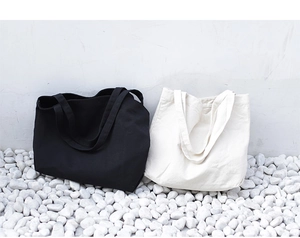 Detail of minimalist canvas tote bags in black and white colors on stone surface
