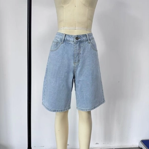 Detail view of light blue denim shorts with vintage washed texture and straight leg cut