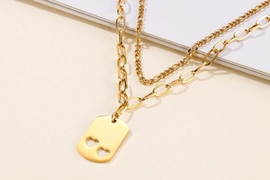Close-up of double-layer gold necklace featuring hollow heart rectangle pendant details