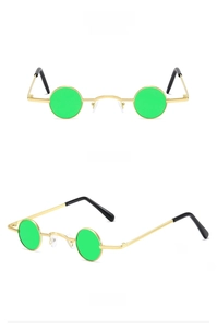 Detail view of small round punk sunglasses with gold metal frames and green lenses