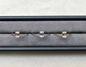 Macro view of emerald-cut moissanite rings in rose gold, silver, and gold finishes