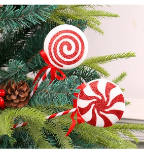 Close-up of red and white glitter Christmas lollipop ornaments with red ribbon on a tree