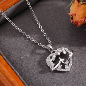 Macro di un ciondolo a cuore in argento traforato con dettagli in zircone e stella