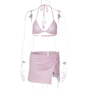 Detailed view of pink bikini top and polka dot wrap skirt on a display mannequin
