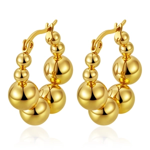 Macro shot of gold-plated geometric beaded hoop earrings with smooth metallic finish