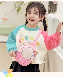 Detail of pink strawberry cupcake cartoon crossbody bag on child model in cozy outfit