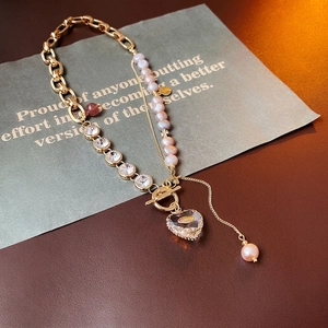 Asymmetric gold chain necklace with pink freshwater pearls and a heart crystal pendant