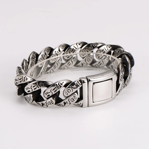 Detail of vintage silver totem chain bracelet with engraved charms and toggle clasp