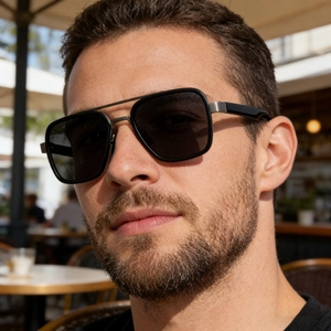 Close-up of black polarized aviator sunglasses with metal double bridge on male model