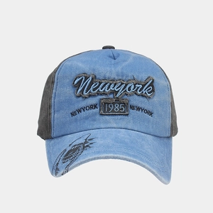 Detail of embroidered Newyork 1985 text on washed blue vintage cotton baseball cap