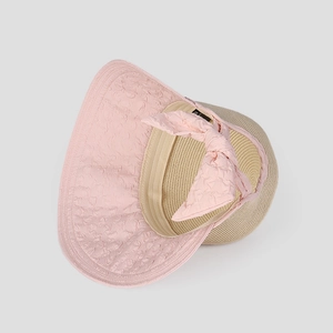 Close-up of a wide brim sun hat with pink bow detail and woven straw texture