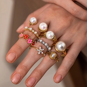 Macro shot of gold floral ring set with pearls and rhinestones on a female hand