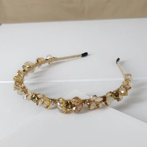 Close-up of handmade champagne crystal beaded headband with gold wire detailing