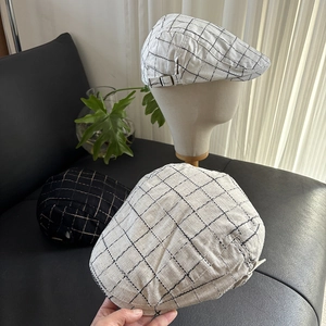Detail of adjustable metal buckle and breathable linen plaid texture on flat cap