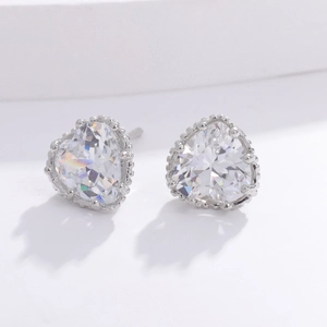Detailed view of silver heart-shaped stud earrings with clear sparkling zircon stones