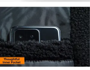 Detail view of the deep internal pocket of a black fleece jacket holding a large smartphone