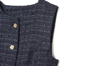 Détail du tissu en tweed avec fil métallique et boutons dorés gaufrés sur le col rond chic