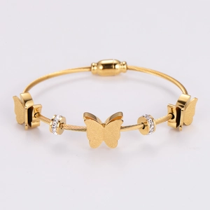Close-up of gold wire bracelet with matte butterflies and sparkling zircon beads