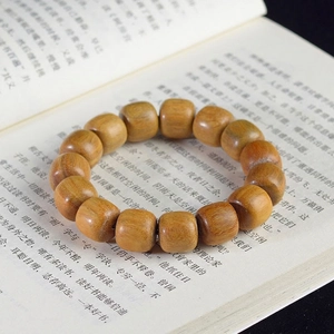 Detailed macro of green sandalwood prayer beads showing natural wood grain and texture