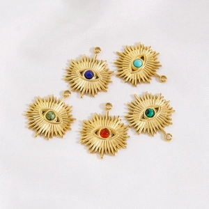 Gold starburst evil eye pendants with assorted gemstone inlays on white textured fabric