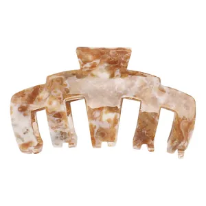 Macro view of a large acetate claw clip featuring brown and white marble texture patterns