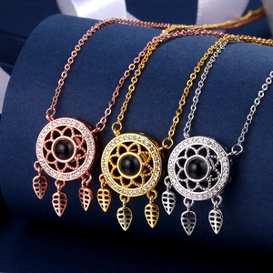 Detailed view of dreamcatcher pendants in rose gold, gold and silver with zircon inlays
