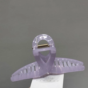 Close-up of large light purple jelly hair claw clip with golden metal spring detail