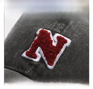 Close-up of vintage washed black baseball cap with 3D red N letter embroidery detail