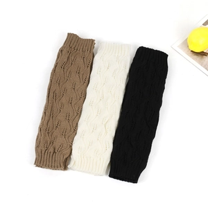 Three-color chunky knit leg warmers in brown, beige, and black with hollow leaf patterns