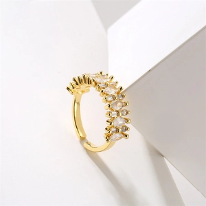 Detail of adjustable gold ring featuring alternating marquise and baguette cut zircons