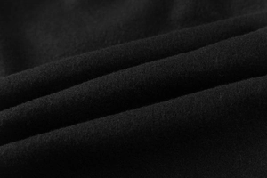 Gros plan sur le tissu polaire noir doux avec texture détaillée et plis élégants