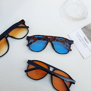 Three pairs of oversized vintage sunglasses displayed on a modern decorative tray