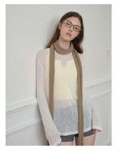 Close-up of brown skinny knit scarf showing detailed vertical ribbed texture on model