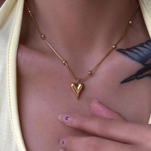 Elegant 18k gold plated heart pendant necklace with beaded chain worn by a female model