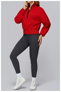 Detail of red half-zip sweatshirt with ribbed cuffs and grey high-waist leggings