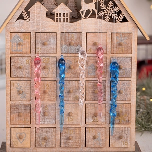 Pink and blue acrylic spiral icicle ornaments hanging on a wooden Christmas calendar