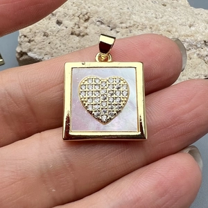 Golden square pendant with heart motif and sparkling crystals on white mother of pearl