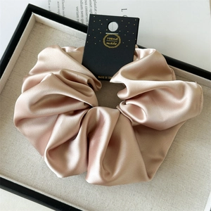 Detail of champagne satin oversized hair scrunchie in a premium display tray