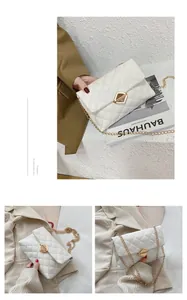 Detailed view of white quilted crossbody bag featuring golden geometric metal lock