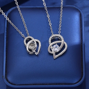 Detail of heart pendant showing 'I love you to the moon and back' engraving and projection stone