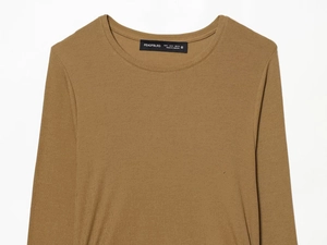Close-up detail of the brown knitted long sleeve top showing neckline and ribbed texture