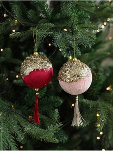 Velvet Christmas ball with gold sequins and silk tassels on a festive tree