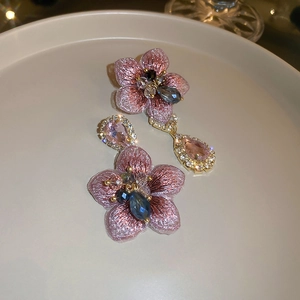 Detailed close-up of pink embroidered flower earrings with teardrop crystal pendants