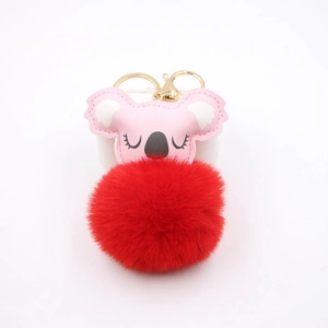 Close-up of pink koala plush keychain with a red pompom and golden metal clasp