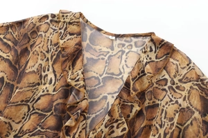 Detailed close-up of V-neckline with leopard print and ruffle trim on a chiffon midi dress