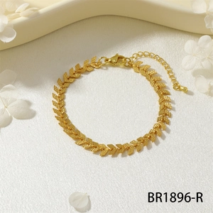 Dettaglio del bracciale a catena dorata con maglie a V testurizzate e chiusura a moschettone